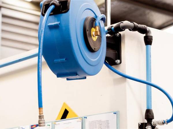Air hose reel mounted on factory wall