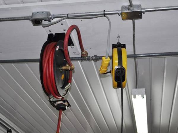 Air hose reel mounted in the ceiling of automotive repair shop