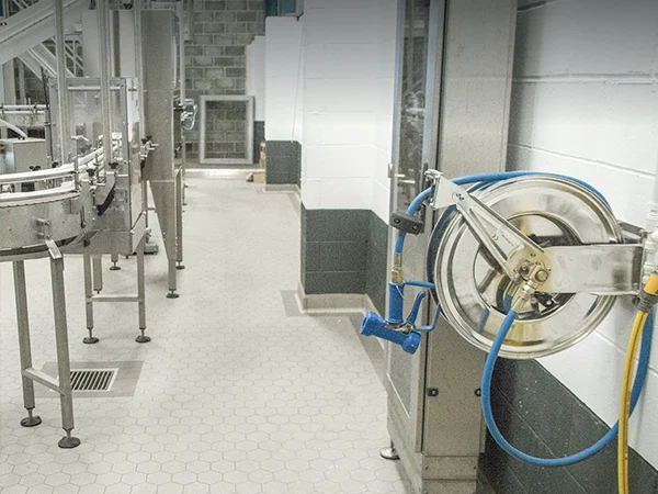 Food processing plant uses food-grade stainless steel hose reel with hose.