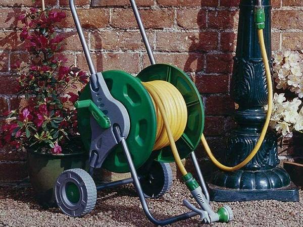 The hose of retractable garden hose reel is receiving water under the faucet.