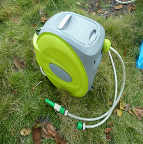 green color automatic retractable hose reel on grassland