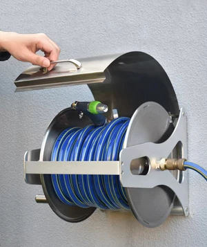 A person opening the cover of the stainless steel wall mount hose reel with their hand